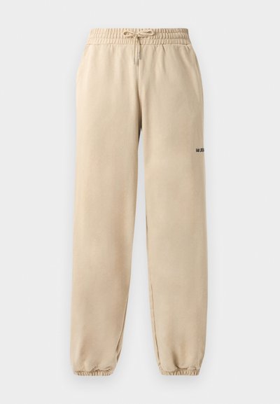 Beige sweatpants with an elastic waistband and drawstring, featuring a cuffed hem and minimal branding on the side. Smooth texture.