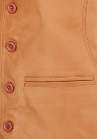 Tan leren vest met vijf ronde roze knopen, een platte zak en een gladde afwerking met subtiele textuur. Gestikte details rond de randen.