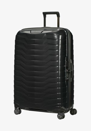 Black hard-shell suitcase with a textured surface, geometric pattern, extendable handle, four spinner wheels, and a zippered opening.