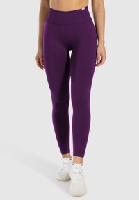 Lila high-waisted Leggings aus dehnbarem Stoff, figurbetontes Design, in voller Länge, mit glatter Textur und minimalen Nähdetails.