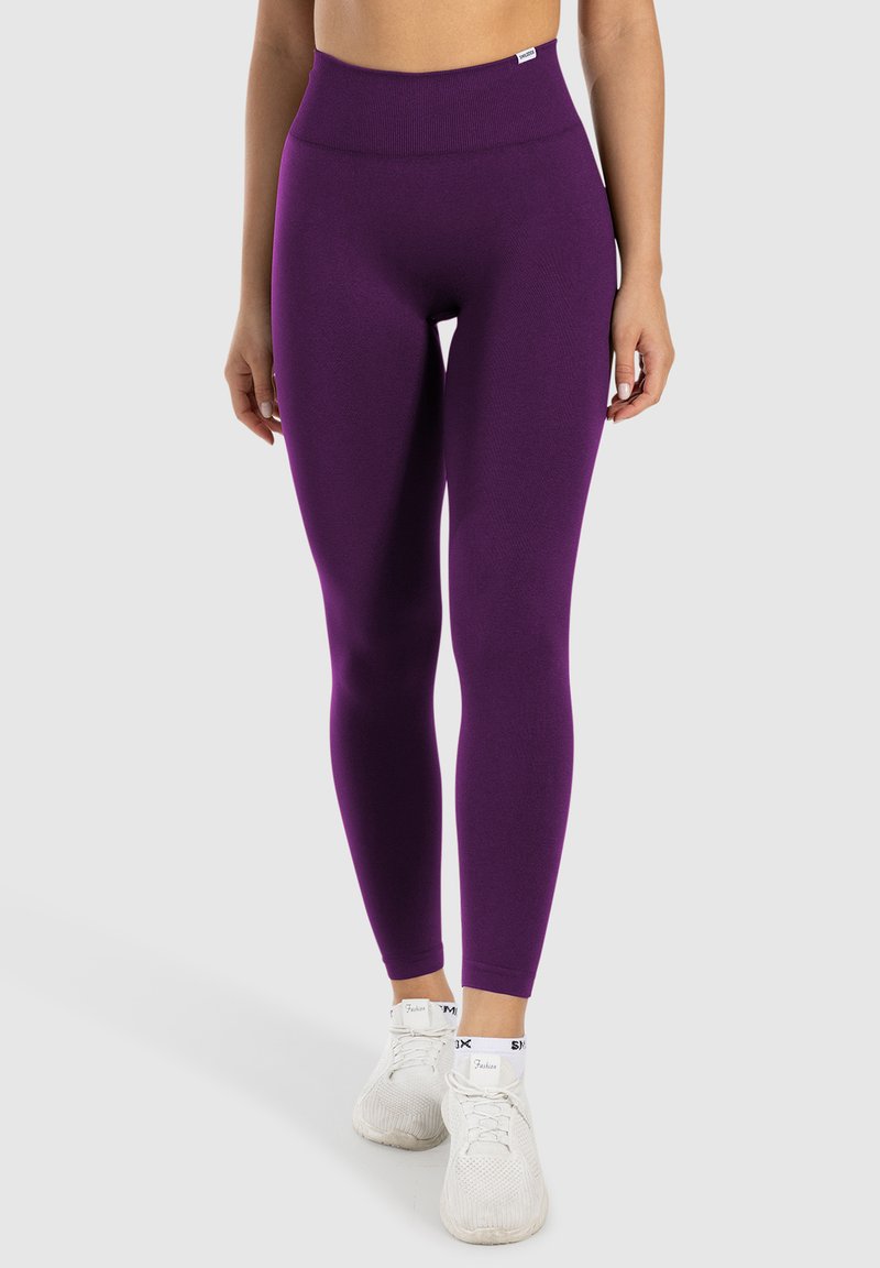 Lila high-waisted Leggings aus dehnbarem Stoff, figurbetontes Design, in voller Länge, mit glatter Textur und minimalen Nähdetails.