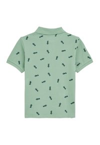 Grön bomullspolo med ett upprepande mörkgrönt grafiskt mönster. Kortärmad, klassisk krage och mjukt material.