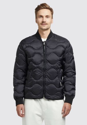 Schwarze gesteppte Bomberjacke mit Reißverschluss vorne, gerippten Bündchen und einem strukturierten Muster. Leichtes Material mit tailliertem Design.