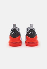 Nike Air kedai pilki pilkojoje tinklelioje su juodais akcentais, turintys ryškiai oranžinius oro pagalvių padais ir atšvaitinį logotipą ant kulno.