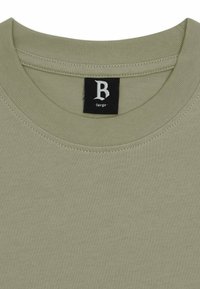 Helles olivgrünes Baumwoll-T-Shirt mit einem gerippten Rundhalsausschnitt und einem kleinen schwarzen Etikett mit einem weißen 'B' und dem Wort 'large' darin.