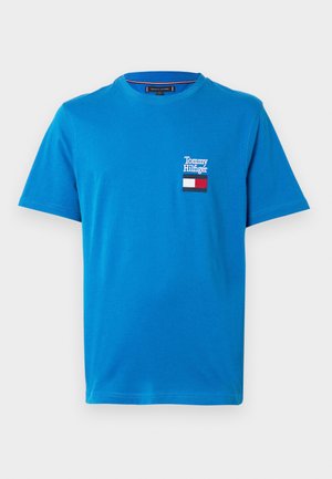 Blaues Baumwoll-T-Shirt mit rundem Ausschnitt, kurzen Ärmeln und einem bestickten Tommy Hilfiger Logo-Patch mit roten, weißen und blauen Akzenten.