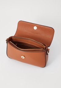 Brązowa skórzana torba na ramię o teksturowanej powierzchni, złote okucia. Posiada główną komorę z kieszenią na zamek oraz dwoma miejscami na karty wewnątrz.