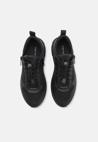 Czarne buty sportowe z siateczkową cholewką, gumową podeszwą, skośnym systemem sznurowania oraz pętelką ułatwiającą zakładanie. Teksturowane elementy dodają detali.