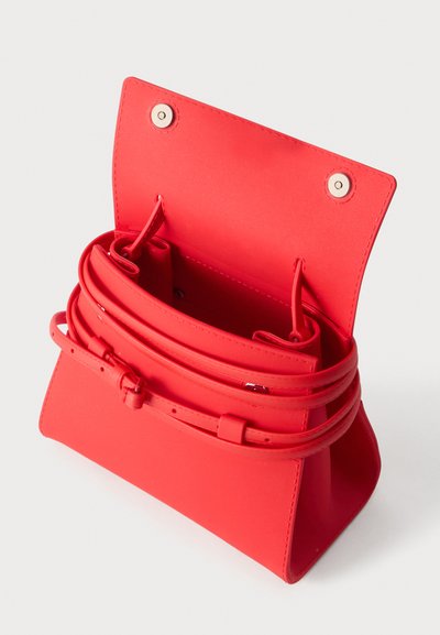 Κόκκινη δερμάτινη τσάντα με ανοιχτό καπάκι, ορατές εσωτερικές θήκες και περιελισσόμενο ρυθμιζόμενο λουράκι σε ανοιχτό φόντο.