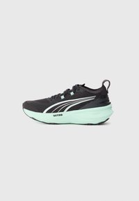 Chaussure de course noire et vert menthe avec tige en tricot, fermeture à lacets, languette de traction et épaisse semelle intermédiaire marquée Nitro.