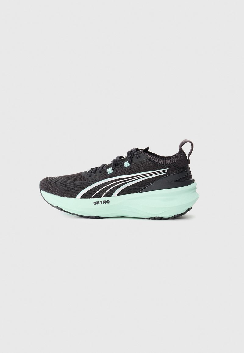 Chaussure de course noire et vert menthe avec tige en tricot, fermeture à lacets, languette de traction et épaisse semelle intermédiaire marquée Nitro.