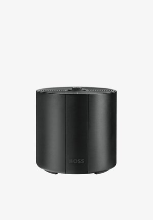 Haut-parleur sans fil cylindrique noir compact avec molette de réglage en haut et logo "BOSS" sur la face avant.