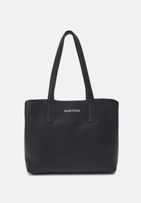 Borsa tote nera Valentino con due manici e logo dorato centrato sul davanti, esposta su uno sfondo bianco.