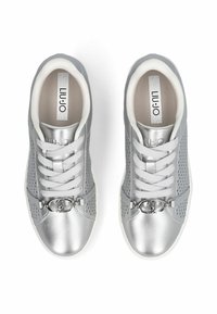 Baskets grises avec empeigne synthétique perforée, accents argentés, lacets plats et un détail métallique sur le cou-de-pied. Semelle en caoutchouc blanche.