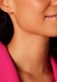Boucle d'oreille en argent au design minimaliste. Texture lisse et forme compacte. Portée à l'oreille, mettant en valeur une esthétique moderne et épurée.