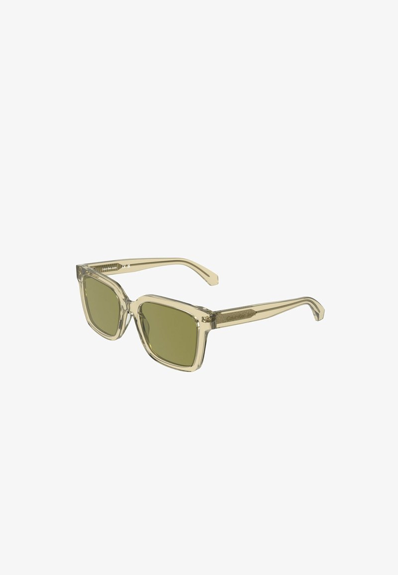 Lunettes de soleil carrées à monture transparente beige avec des verres teintés verts.