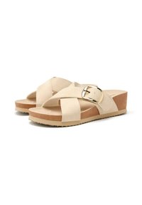 Sandalias beige con correas cruzadas, que cuentan con una hebilla dorada en el lateral. Suela gruesa tipo corcho con un fondo texturizado para mayor agarre.
