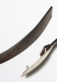 Bruine leren riem met een gladde textuur, meerdere verstelgaten en een ronde metalen gesp met een zilveren afwerking.