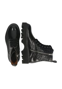 Botas de cuero negro con un acabado liso, panel texturizado con un patrón tejido, cierre de cremallera y una suela de goma gruesa con surcos profundos.