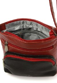 Rood en zwart leren schoudertas met drie ritscompartimenten en een zilveren binnenvoering. Textuur oppervlakte, contrasterende stiksels.