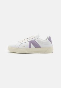 Zapatillas de cuero blancas con acentos de ante morado claro, que cuentan con una suela texturizada color crema y una marca en relieve en el lateral.