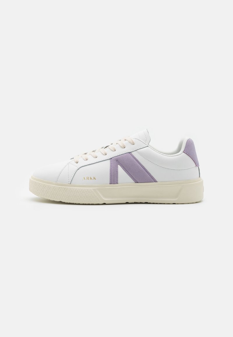 Zapatillas de cuero blancas con acentos de ante morado claro, que cuentan con una suela texturizada color crema y una marca en relieve en el lateral.