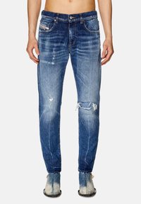 Blekt blå denimjeans med en smal passform, med slitna partier och fransiga fållar. Innehåller fem fickor och en knappstängning.