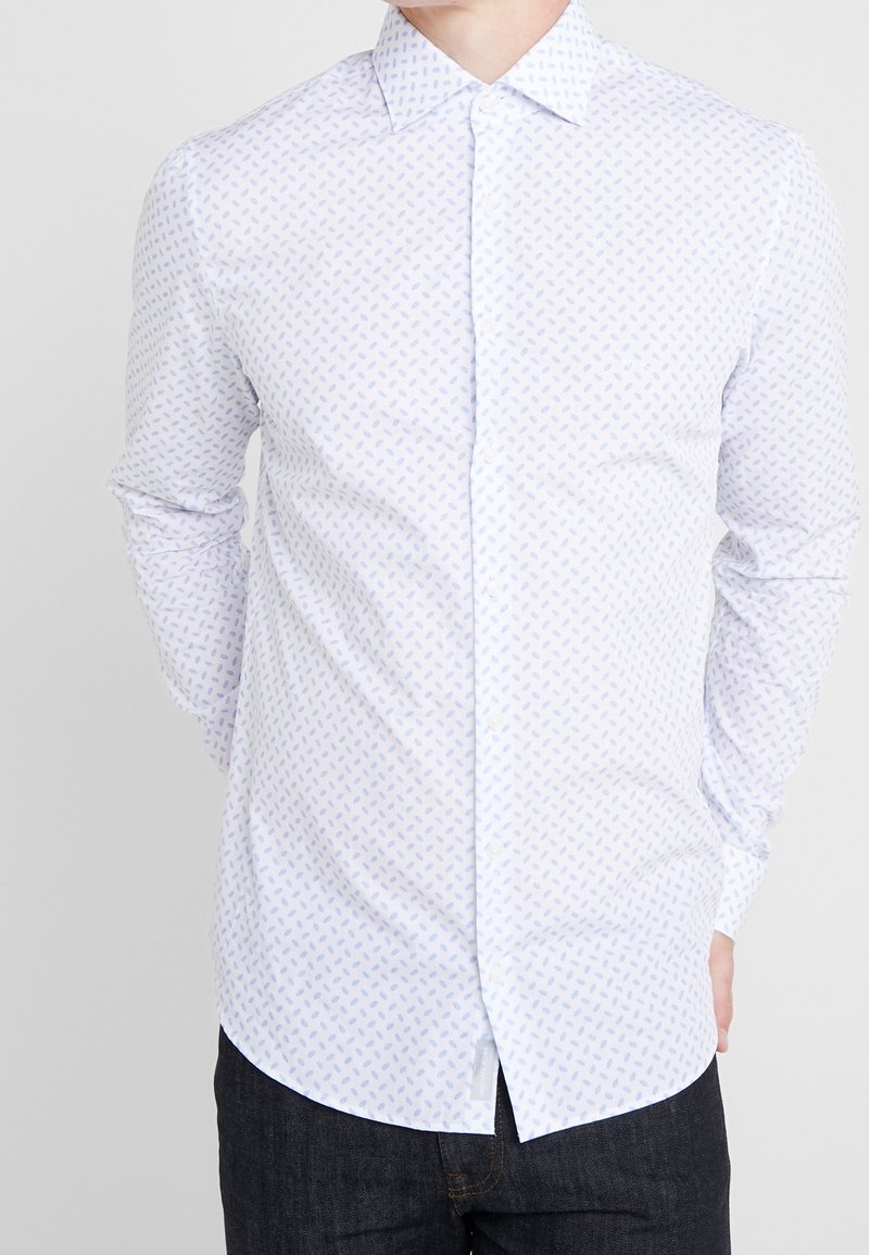 Vit skjorta med knappar och en diskret blå bladmönster, långa ärmar, klassisk krage och slät bomullstyg.