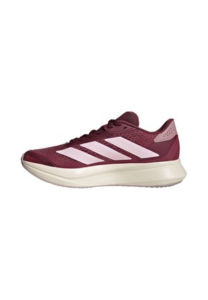 Zapatilla de running marrón oscuro y rosa con suela blanca y tres grandes rayas rosas en el lateral, vista desde el lado exterior.