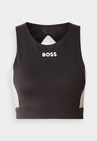 Top corto sportivo nero con schiena a chiave, caratterizzato dalla scritta bianca "BOSS" e inserti laterali beige. Realizzato in tessuto elastico e liscio.