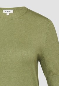 Lichtgroene gebreide top met korte mouwen, ronde hals en s.Oliver merklabel, maat 36, zichtbaar aan de binnenkant van de kraag.