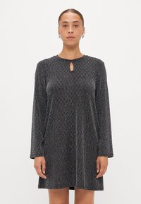 Abito lungo nero a maniche lunghe con scollatura a chiave, motivo testurizzato e vestibilità morbida. Presenta un materiale morbido e leggermente lucido.