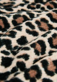 Leopardprint stof med en blød, struktureret overflade i sorte, brune og beige nuancer, prydet med et mønster af pletter og former.