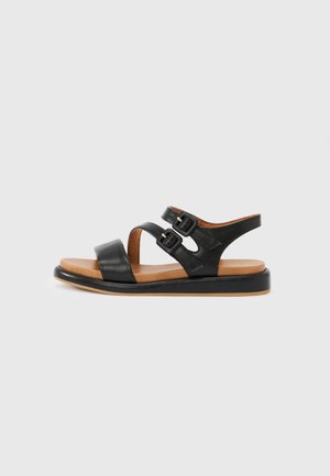 Zwarte leren sandaal met twee verstelbare gespsluitingen, platte bruine zool, open teenontwerp en een gladde textuur. Geschikt voor casual gebruik.