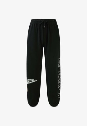 Pantaloni della tuta neri con vita elasticizzata e cordoncino. Presentano una grafica di ali e il testo "ED HARDY" in bianco lungo una gamba.