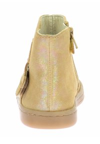 Stivaletto alla caviglia in suede oro caratterizzato da una texture liscia, chiusura con zip e una sottile lucentezza iridescente sul materiale. Suola in gomma solida.