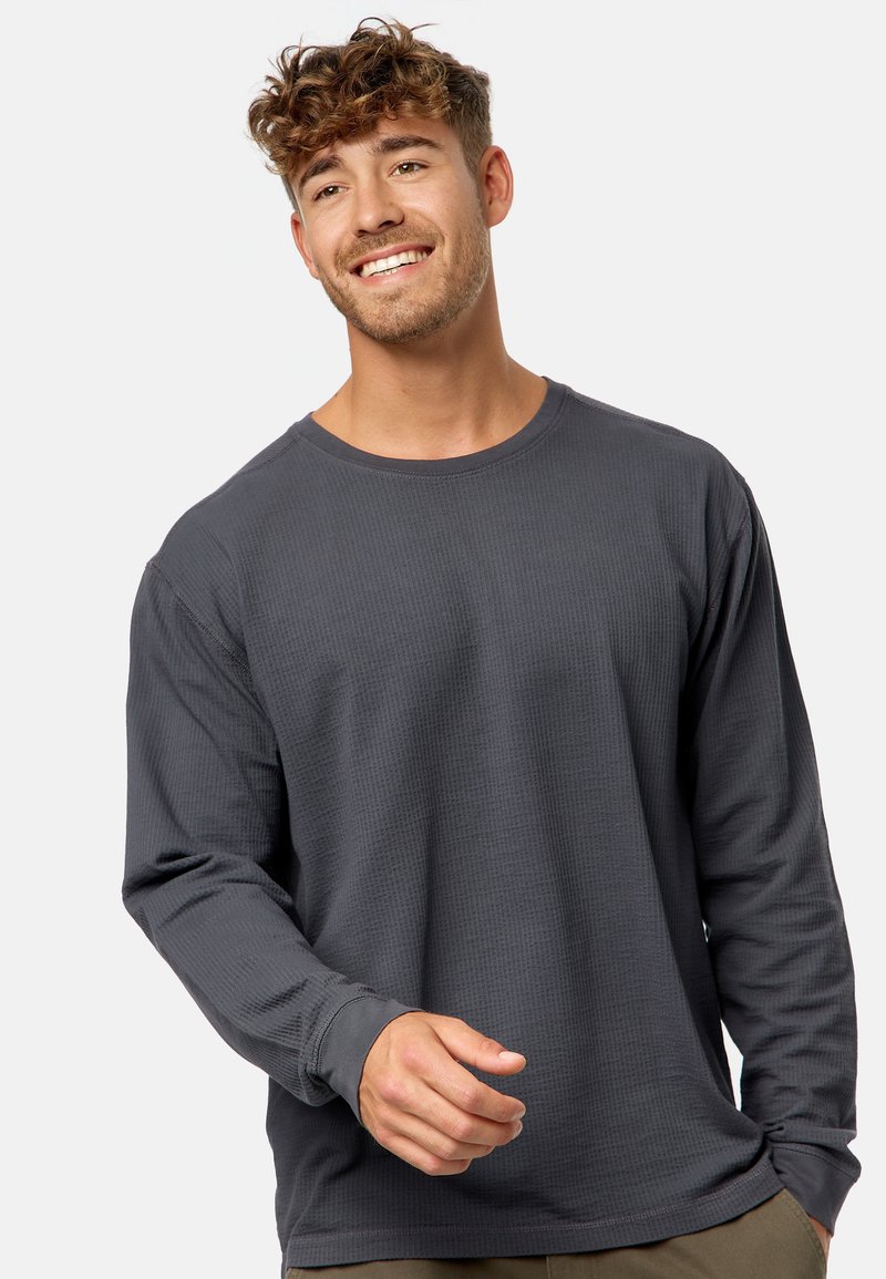 Langarmshirt aus grauem, strukturiertem Stoff mit Rundhalsausschnitt und lässiger Passform. Nahtdetails und ein leichter Stretch sind sichtbar.