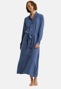 Langes Hemdkleid aus weichem blauen Stoff, mit einem Gürtel zum Binden, langen Ärmeln und geradem Schnitt mit leicht ausgeprägter A-Linie.