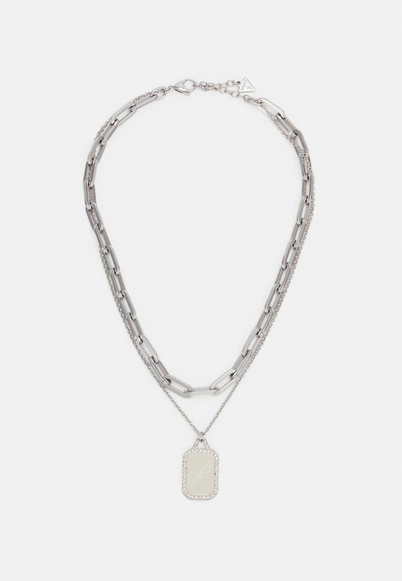 Collier double chaîne en argent avec de grandes mailles et une chaîne plus petite tenant un pendentif rectangulaire bordé de petits cristaux.