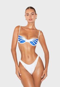 Set di bikini con un motivo a onde blu e bianche. Il top presenta un incrocio frontale e spalline regolabili; il slip a vita alta ha un design arricciato.