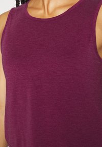 Lila linne av mjukt tyg, med rund halsning och ärmlös design, med en jämn textur och inga synliga mönster.