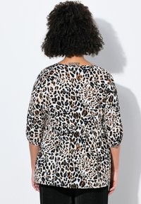 Top con stampa leopardata e maniche a tre quarti, progettato con una vita arricciata, presentando una combinazione di colori nero, marrone e crema.