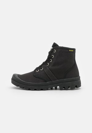 Bottines noires à cheville avec tige en toile, surface texturée, bout rond et semelle en caoutchouc dotée de crans prononcés et de laçage par œillets.
