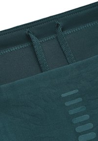 Teal träningsshorts med texturerad tyg, midjeband med dragsko och subtila horisontella r änder längs fållen.