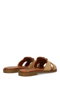 Ett par platta slidesandaler med bruna sulor och vävda beige remmar med utskärningar och guld accenter.