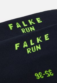 Navy running socks with green "FALKE RUN" lettering. Features a smooth texture and ribbed design for enhanced comfort and fit.