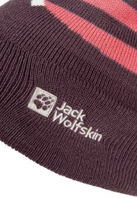 Dunkelviolette Strickmütze mit pinkfarbenen Streifen, ausgestattet mit einem weißen, gestickten Logo von Jack Wolfskin am Bündchen. Weiche Textur.
