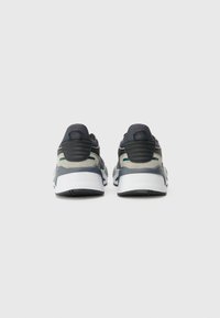 Graue und schwarze Sportschuhe mit einem Obermaterial aus Mesh, Wildlederakzenten und einer weißen Sohle, ausgestattet mit einer strukturierten Ferse und dezenten grünen Details.