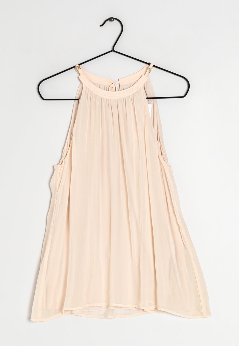 Top senza maniche di un delicato colore pesca chiaro con scollatura tonda, tessuto arricciato e aperture laterali. Realizzato in materiale morbido e leggero. Appeso a un gancio nero.