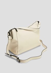 Krémová syntetická crossbody taška s hladkým povrchem, vybavená černým zipem a nastavovací rukojetí. Úhlový design s plochým dnem.